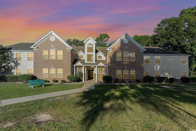view of front of property featuring a front yard and brick siding