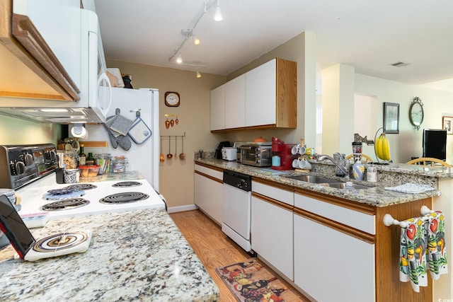 kitchen with light hardwood / wood-style floors, white cabinetry, light stone counters, white appliances, and sink