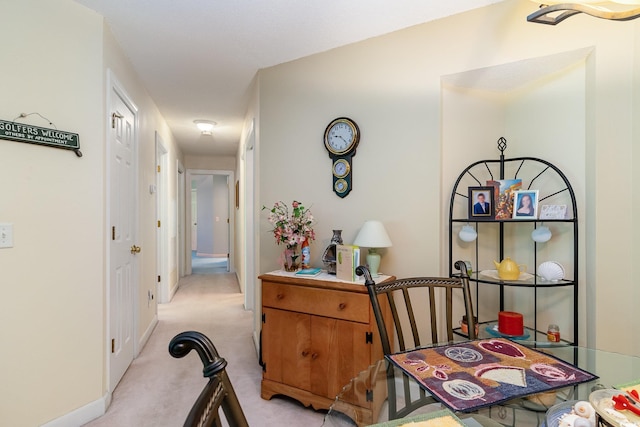 hall with baseboards and light carpet