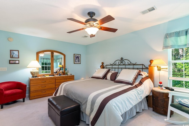 carpeted bedroom with visible vents and ceiling fan