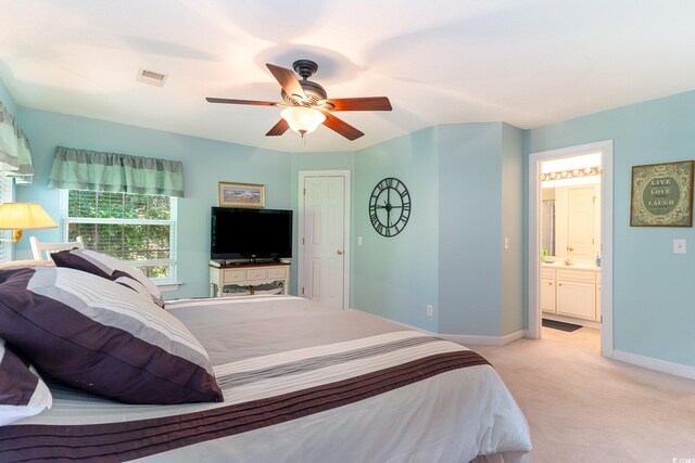 bedroom with visible vents, baseboards, ensuite bathroom, a ceiling fan, and light carpet