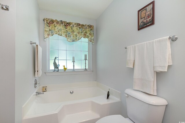 bathroom with toilet and a garden tub