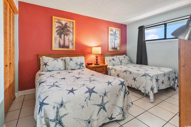 tiled bedroom featuring a textured ceiling and a closet