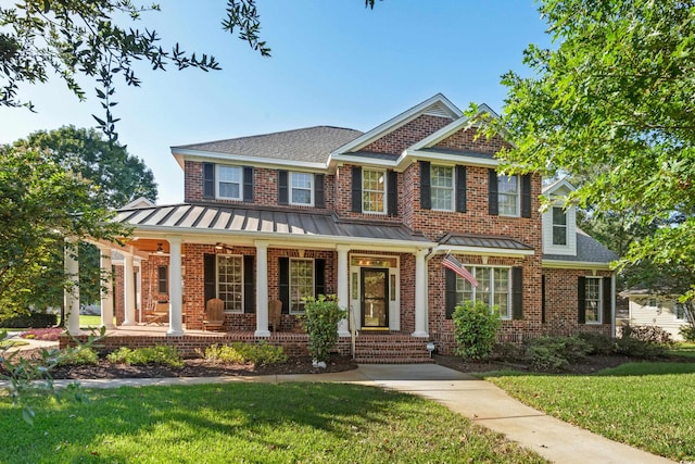 view of front of house featuring covered porch and a front lawn