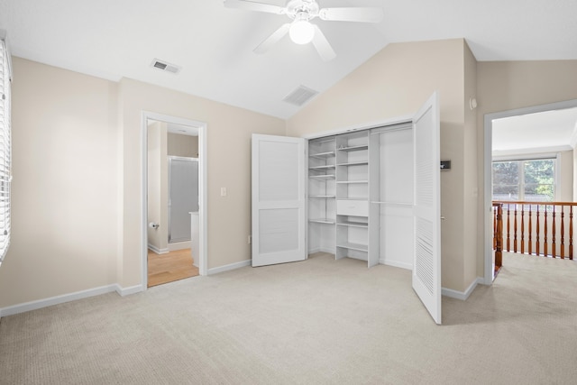 unfurnished bedroom with a closet, ceiling fan, vaulted ceiling, and light colored carpet