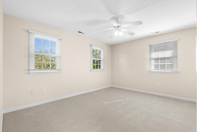 empty room featuring light carpet, a textured ceiling, and ceiling fan