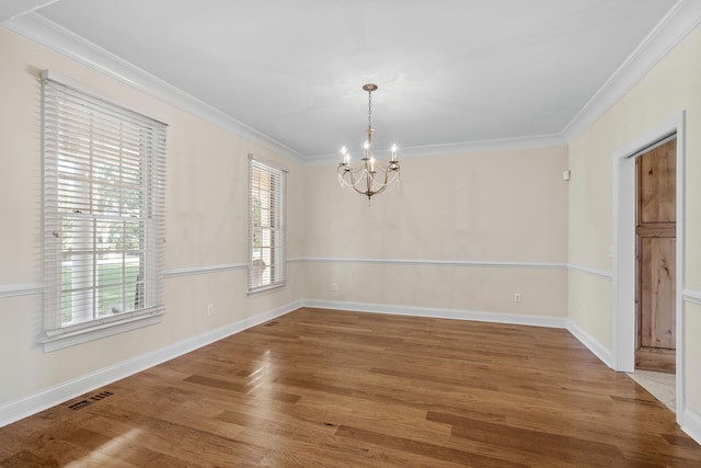 unfurnished dining area featuring a notable chandelier, a healthy amount of sunlight, ornamental molding, and hardwood / wood-style floors