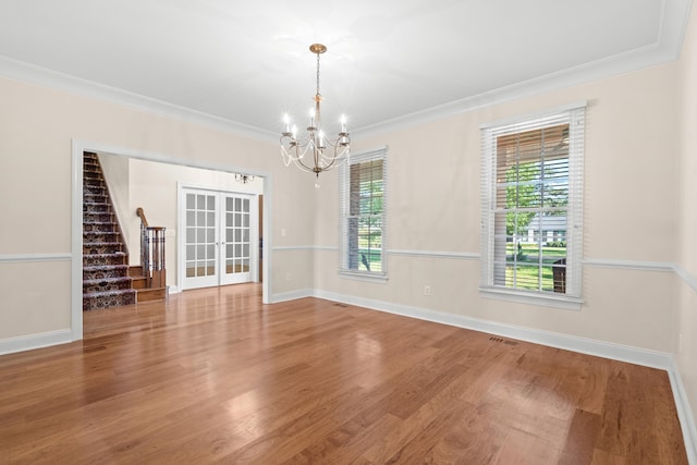 interior space featuring ornamental molding, french doors, hardwood / wood-style floors, and a notable chandelier