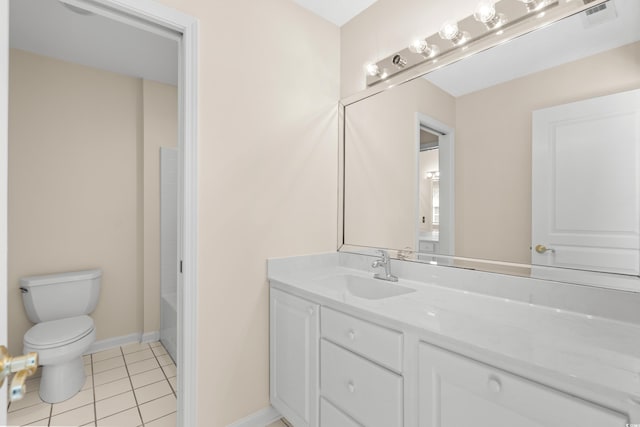 bathroom with toilet, vanity, and tile patterned flooring