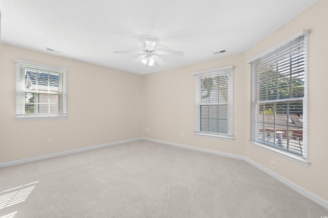 carpeted empty room with a textured ceiling and ceiling fan