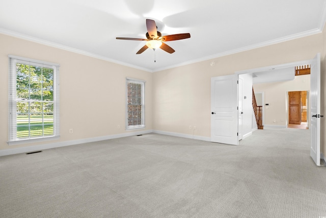 carpeted spare room with crown molding and ceiling fan