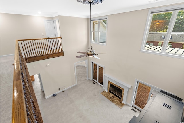 carpeted living room with ceiling fan and crown molding