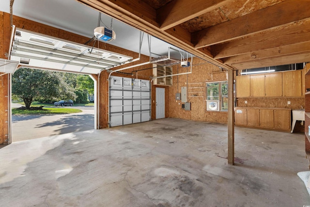 garage with a garage door opener and electric panel