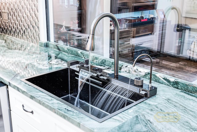 interior details featuring white cabinetry and sink