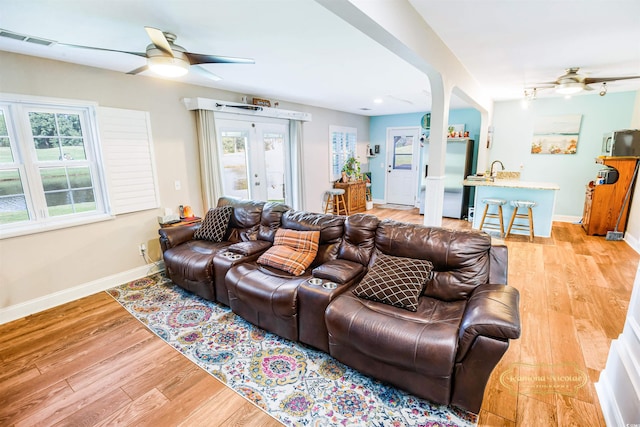 living room featuring ceiling fan, french doors, and light hardwood / wood-style flooring