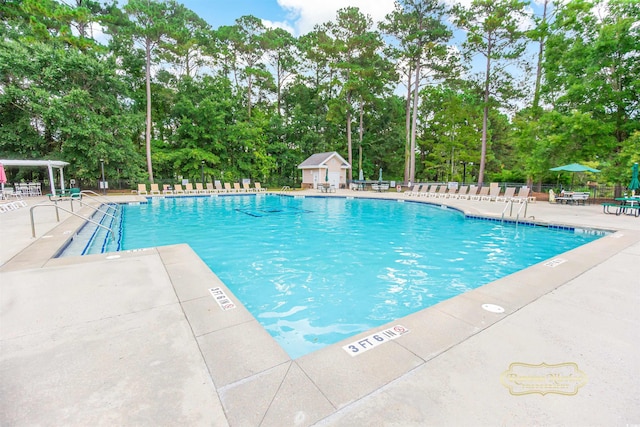 view of swimming pool featuring an outdoor structure and a patio area