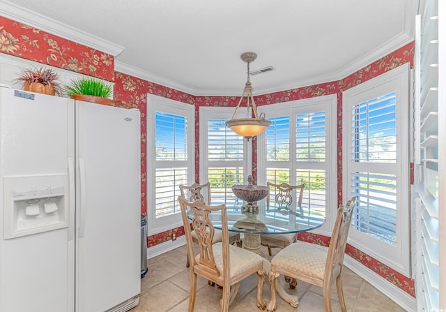 tiled dining space with ornamental molding and a wealth of natural light