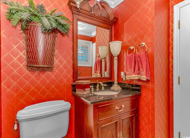 bathroom featuring ornamental molding, vanity, and toilet