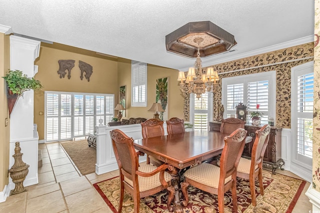 tiled dining area with ornamental molding, a textured ceiling, and a chandelier