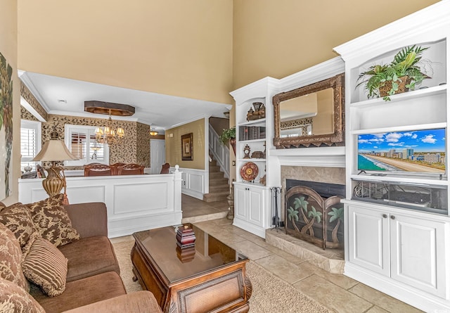 tiled living room with an inviting chandelier, a high ceiling, and ornamental molding