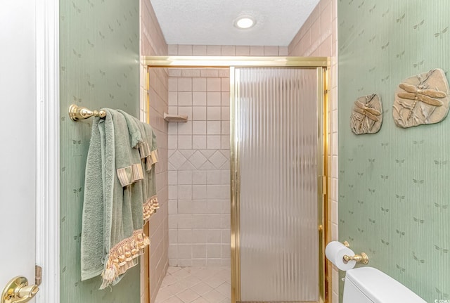 bathroom featuring a textured ceiling, an enclosed shower, and toilet