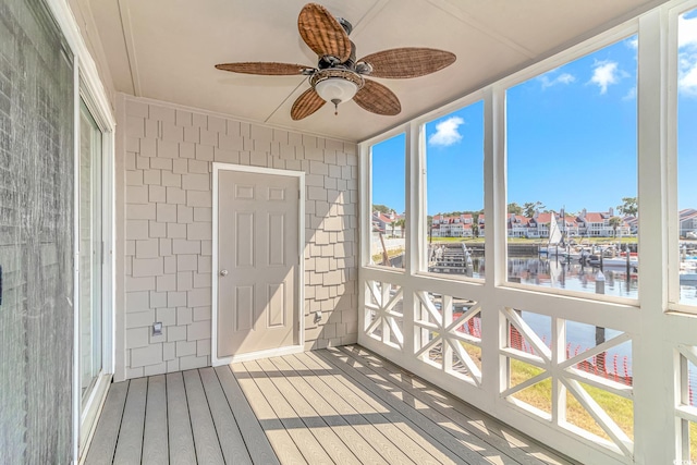 sunroom / solarium featuring a wealth of natural light, a water view, and ceiling fan