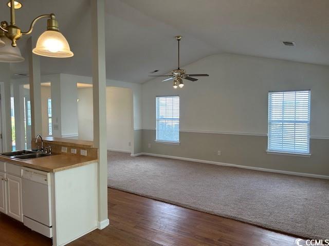 kitchen featuring white dishwasher, dark wood-type flooring, sink, white cabinetry, and lofted ceiling