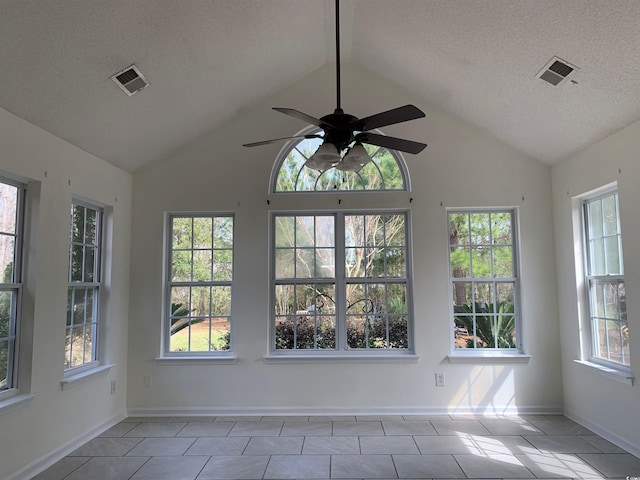 tiled empty room featuring a textured ceiling, high vaulted ceiling, plenty of natural light, and ceiling fan