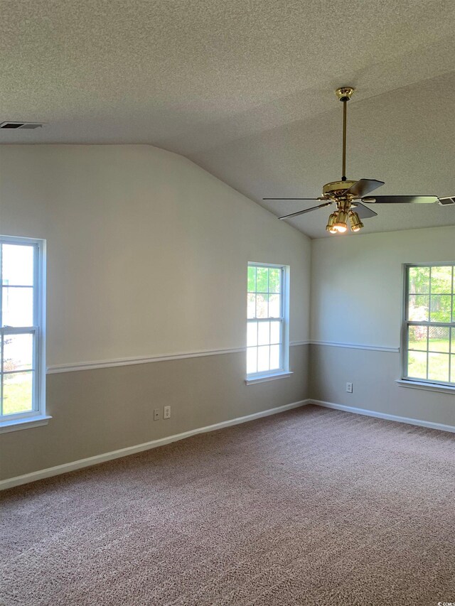 empty room with carpet flooring, a textured ceiling, ceiling fan, and lofted ceiling