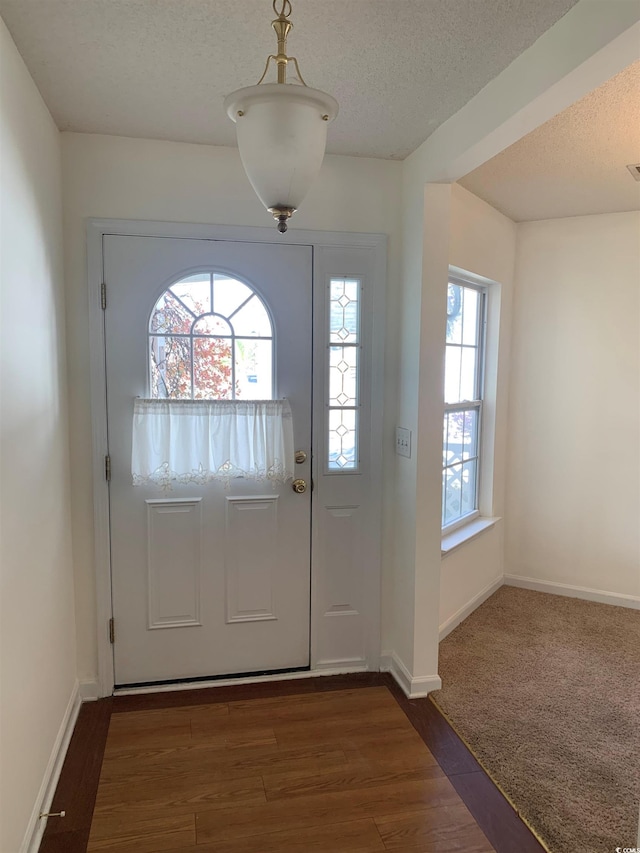 entryway with a textured ceiling and dark hardwood / wood-style floors