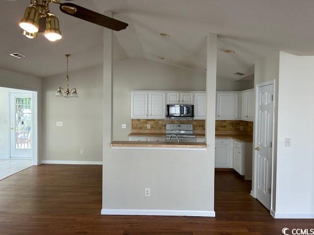 kitchen featuring dark hardwood / wood-style flooring, white stove, white cabinetry, and lofted ceiling