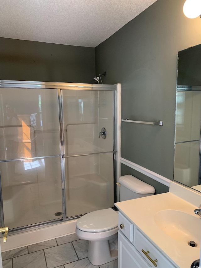 bathroom with vanity, tile patterned flooring, toilet, a textured ceiling, and a shower with shower door