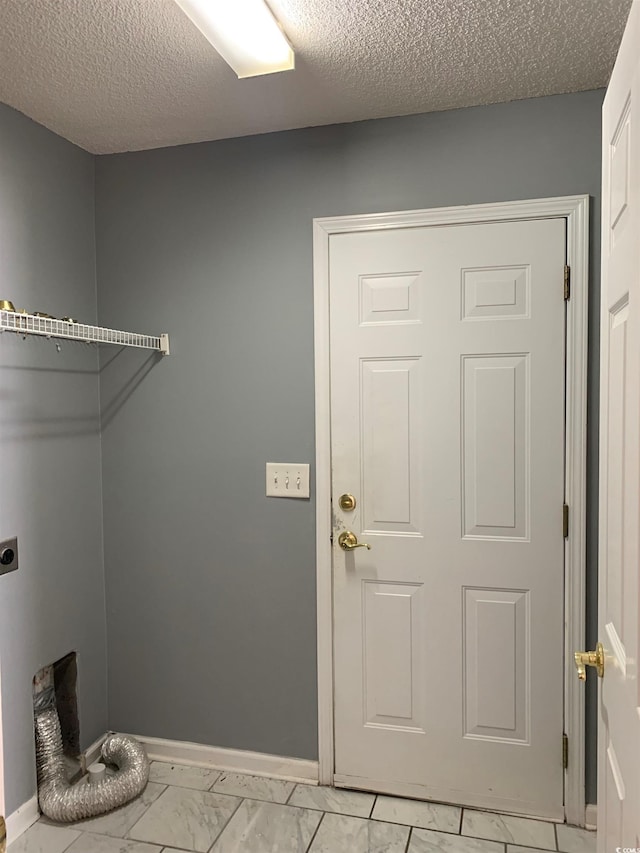 clothes washing area featuring electric dryer hookup and a textured ceiling