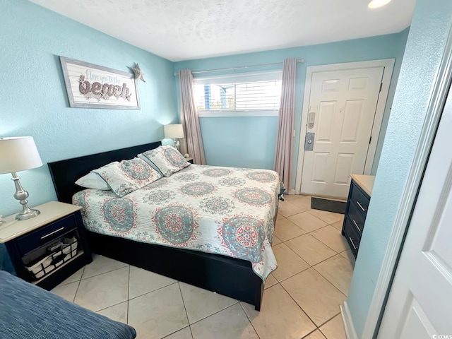 bedroom with a textured ceiling and light tile patterned floors