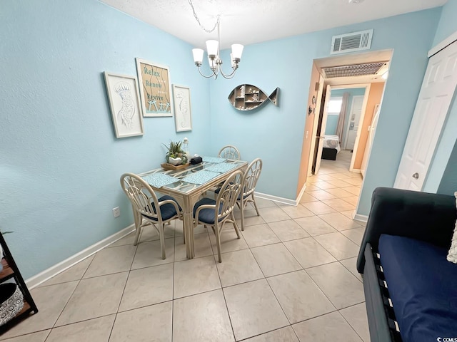 tiled dining room with a chandelier