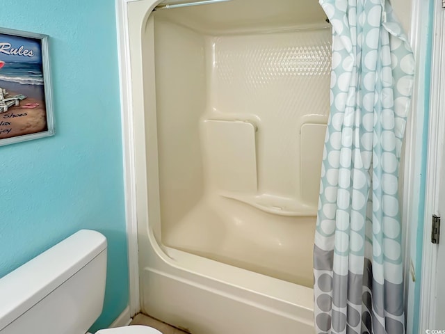 bathroom featuring shower / bath combo and toilet