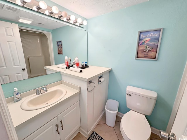 bathroom with tile patterned floors, a textured ceiling, vanity, and toilet