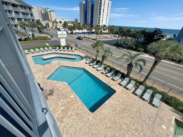 view of pool featuring a patio and a water view