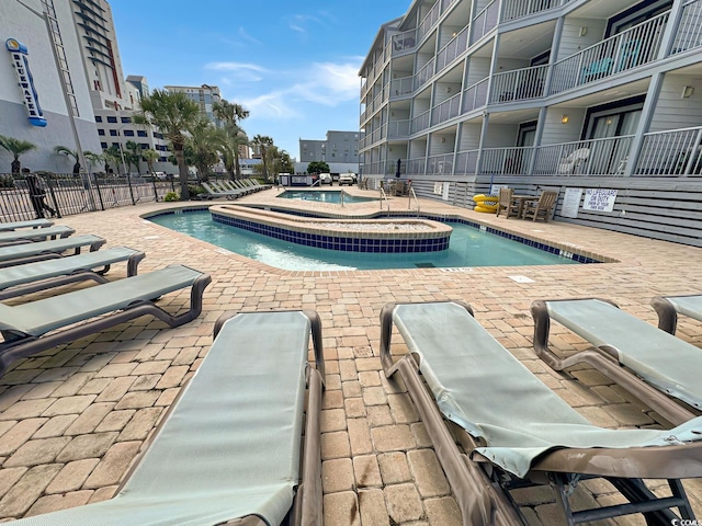 view of pool with a hot tub and a patio