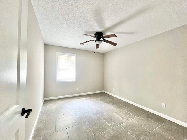 empty room with ceiling fan and a textured ceiling