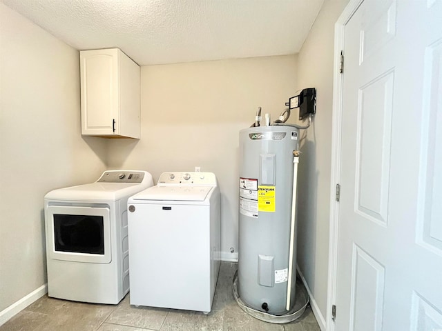 laundry area with cabinets, water heater, a textured ceiling, and washer and clothes dryer