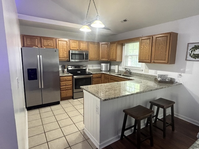 2108 Kirkland Dr, Conway, SC 29526 - kitchen featuring a sink, lofted ceiling, stainless steel appliances, brown cabinetry, and visible vents