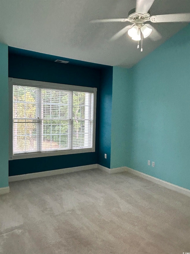 carpeted empty room featuring a wealth of natural light and ceiling fan