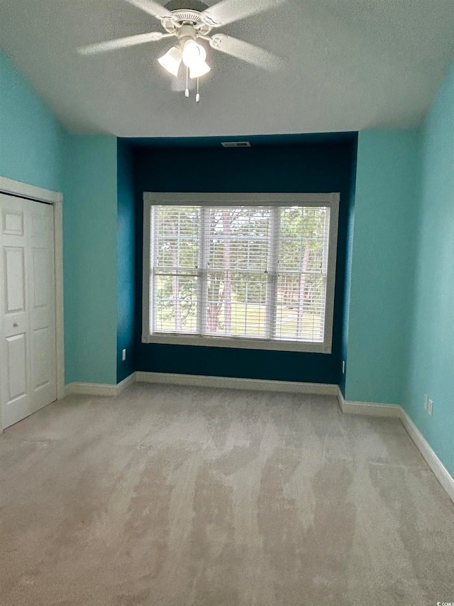 spare room featuring a textured ceiling, ceiling fan, and plenty of natural light