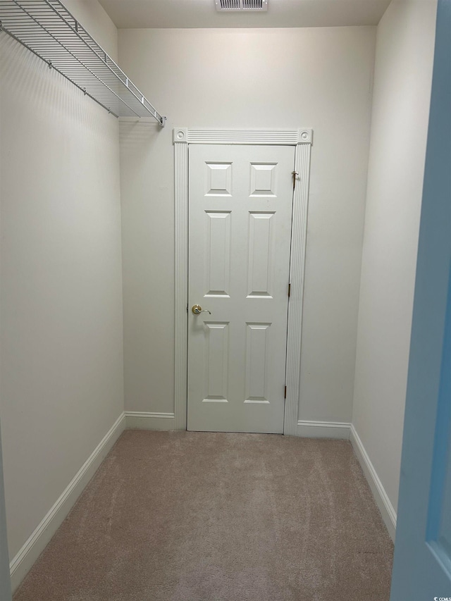 walk in closet featuring light colored carpet