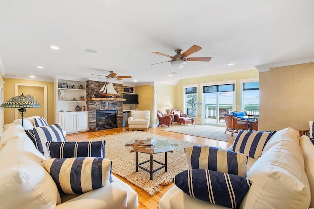 1324 Harbour Watch SW, Calabash, NC 28467 - living area featuring light wood-type flooring, ornamental molding, a ceiling fan, recessed lighting, and a stone fireplace