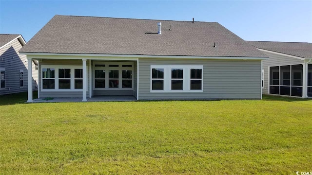 back of property with a lawn, a sunroom, and a patio