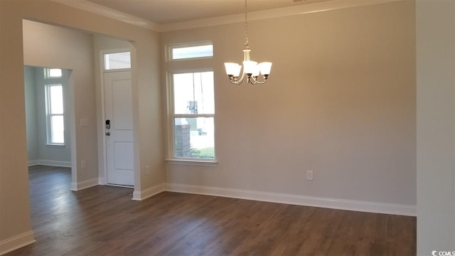 entrance foyer with a notable chandelier, dark hardwood / wood-style floors, ornamental molding, and a wealth of natural light