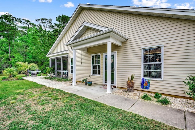 view of exterior entry featuring a lawn