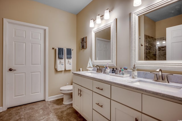 bathroom with vanity, a tile shower, and toilet